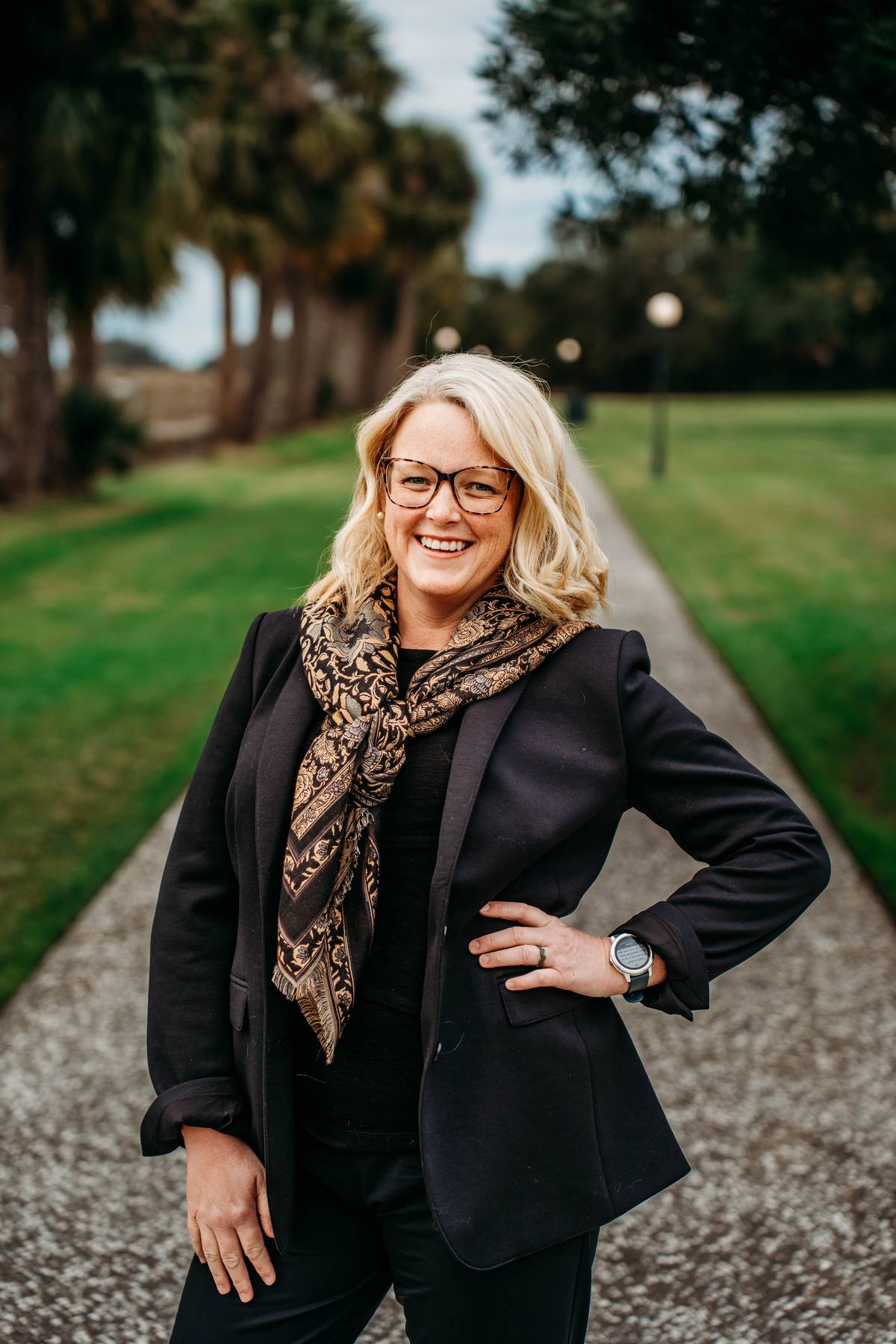 A blonde woman wearing glasses stands on a tabby path in southeast Georgia